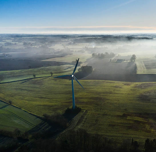 Aerial view of wind mills in hazy winter landscape seen from drone point of view